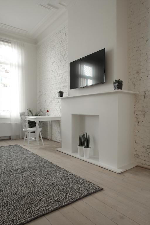 Maison Nationale City Flats & Suites Antwerpen Kamer foto A fireplace with a TV above it